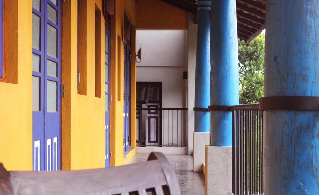 康提Blue Pillars Kandy的坐在蓝色柱子建筑外的长凳