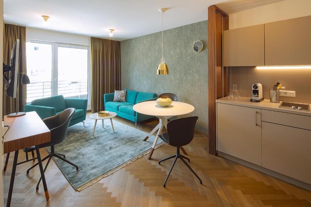 慕尼黑DD套房服务式公寓 的厨房以及带桌子和沙发的客厅。