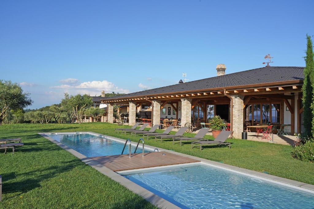 波尔佩纳泽德尔加尔达Pietra Cavalla - Ranch & Resort的庭院中带游泳池的房子