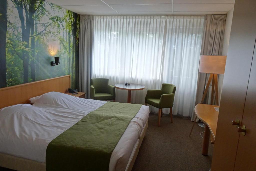 HaarloHCR王子酒店的酒店客房带一张床、一张桌子和椅子