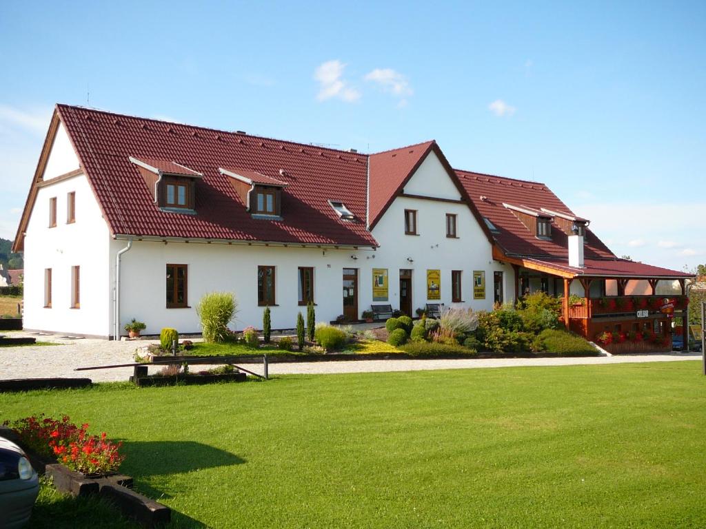 Přísečná普拉克缇克克鲁姆洛夫旅馆的一座大型白色房屋,设有红色屋顶