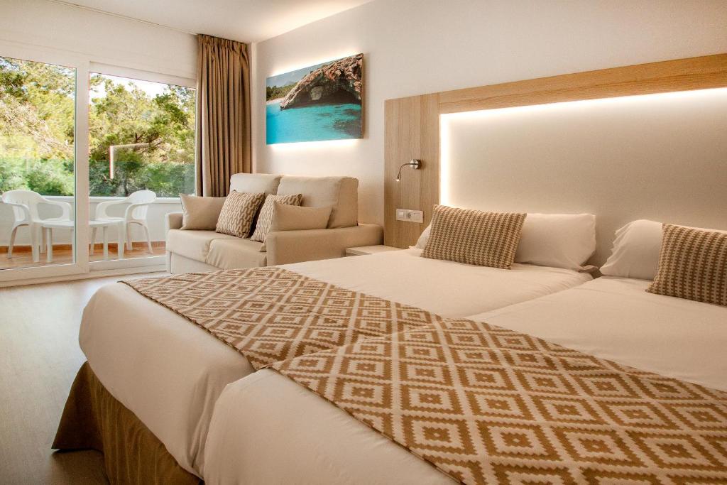 圣蓬萨Globales Costa de la Calma的酒店客房,设有两张床和一张沙发