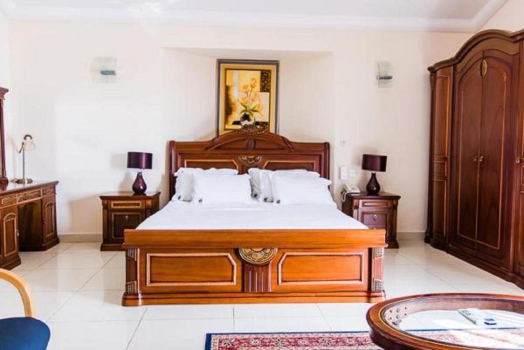弗里敦Hotel Barmoi的一间卧室配有一张大木床和木制家具