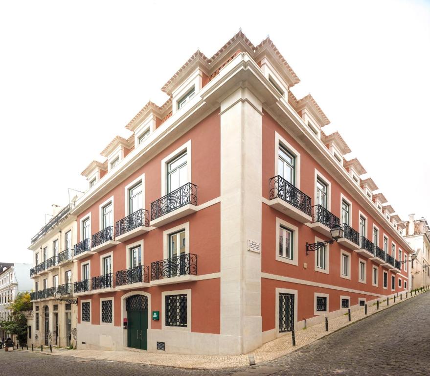 里斯本里斯本服务式公寓 - 希亚多埃门达的街道上一座带阳台的大型红色建筑