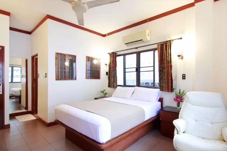 通萨拉布爱考旅馆的卧室配有白色的床和椅子
