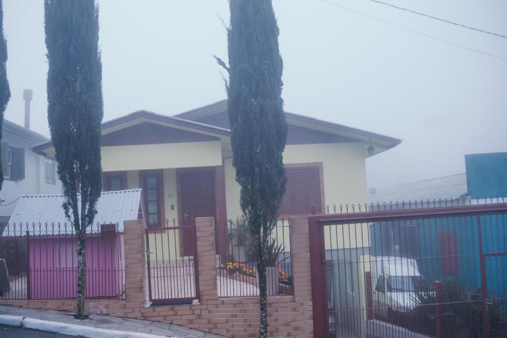 格拉玛多Casa Muller的一座带围栏和两棵棕榈树的房子