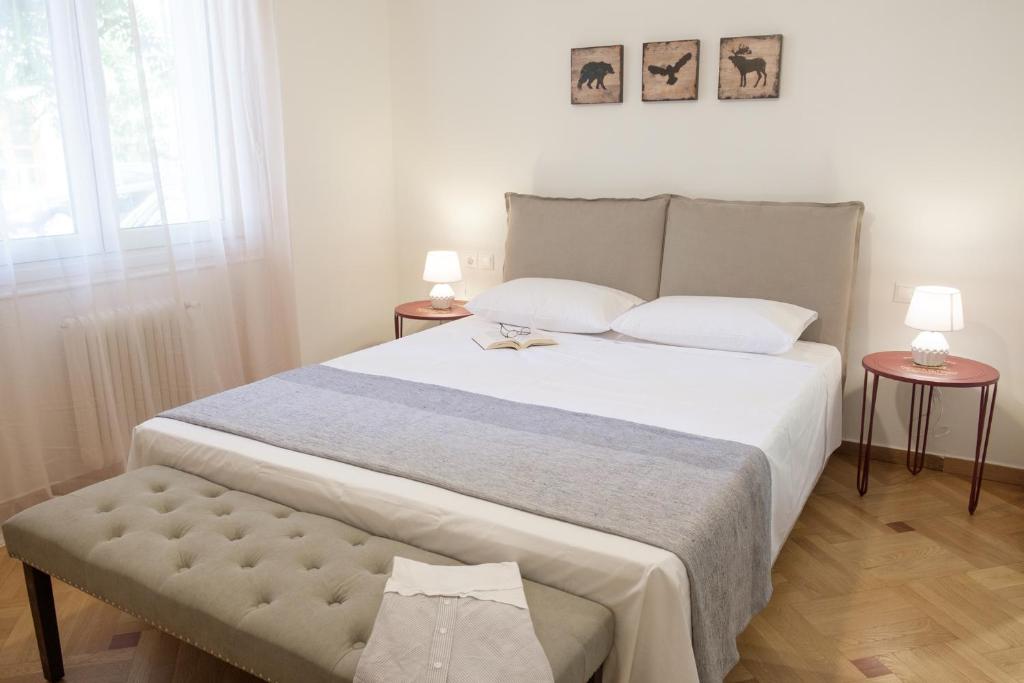 雅典Luxury three bedroom Apartment in Kolonaki的一间卧室配有一张大床和两张桌子