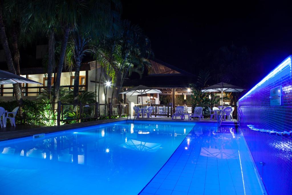 朱奎Pousada Sol e Mar的夜晚的游泳池,灯光蓝色