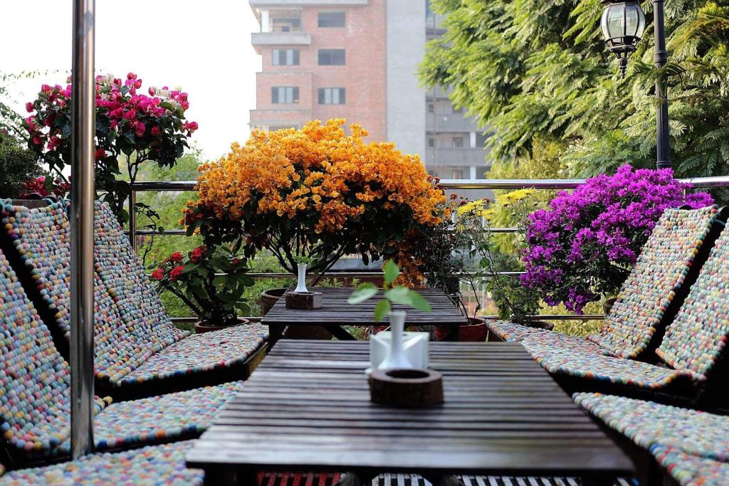 加德满都香格里拉精品酒店的阳台上配有带椅子和鲜花的木桌