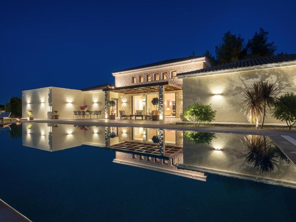 拉加纳斯Villa La Curva的一座晚上设有游泳池的房子