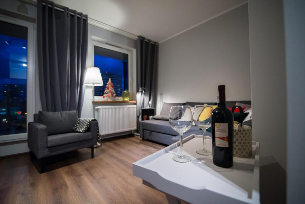 卡托维兹Katowice City Centre Apartment的客厅配有一瓶葡萄酒和两杯酒