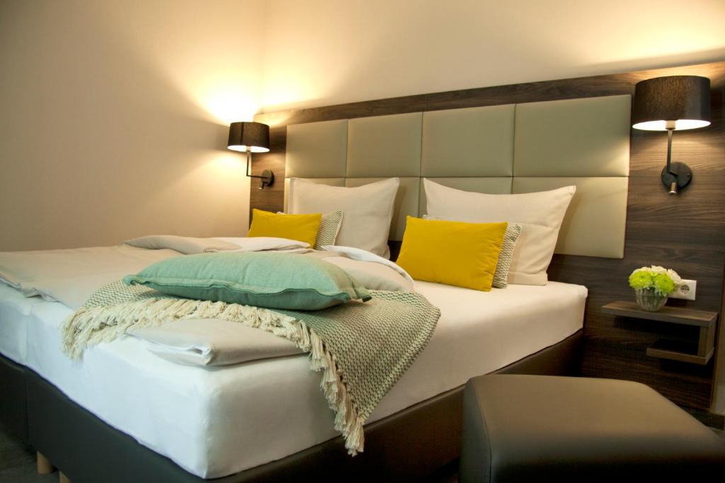 艾汀Hotel Am Moosrain Garni的一间卧室配有黄色和白色枕头的床