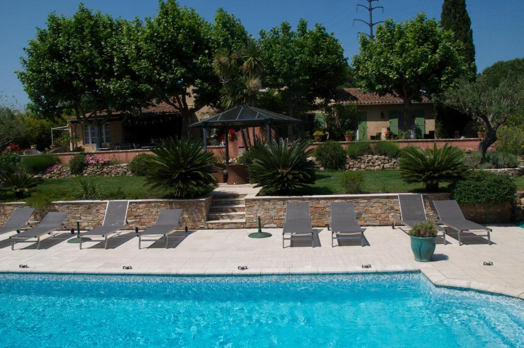 格里莫德阿维兰城堡庄园酒店的一个带躺椅的游泳池以及一座房子