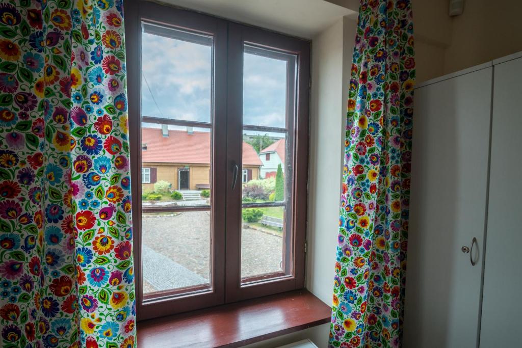 兹盖日Hostel FOLKier的窗户配有窗帘,享有庭院的景色