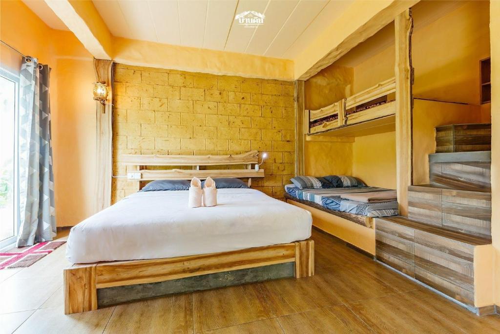 Ban Tha Khun巴丁巧兰度假酒店的一间卧室配有一张床和双层床