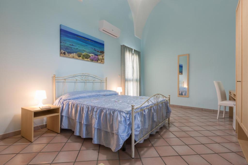 乌真托Le Dimore dei Messapi的卧室配有1张床、1张桌子和1把椅子