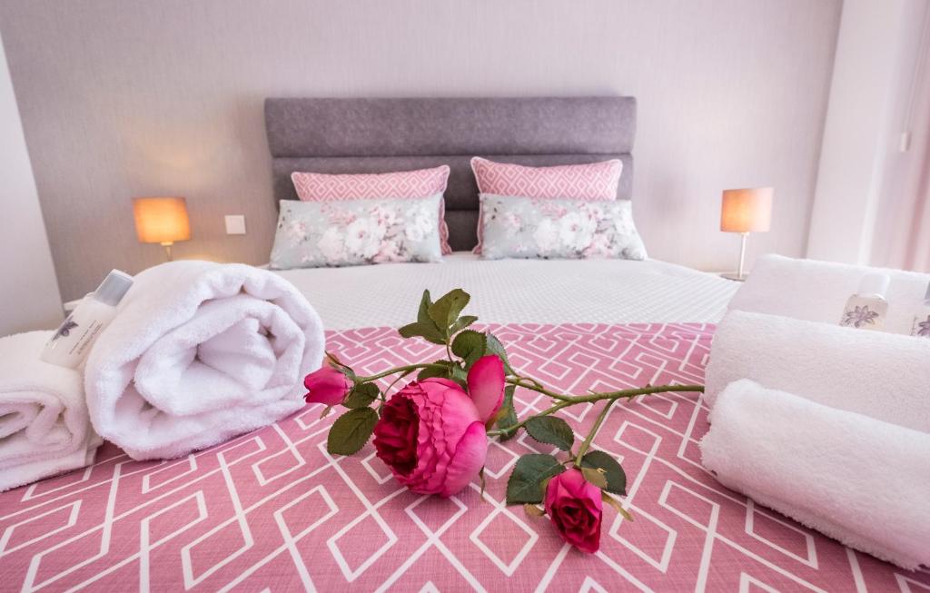 法蒂玛Alto das Nogueiras House Fátima的粉红色的卧室,床上有玫瑰花床