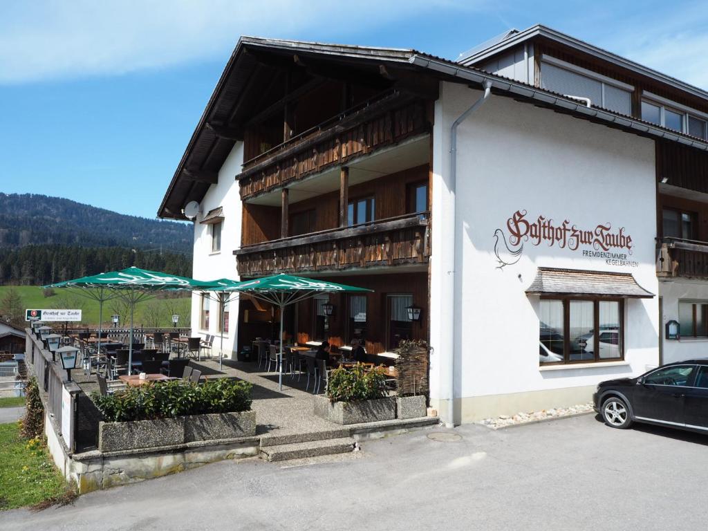 苏尔茨贝格Pension & Gasthof zur Taube的建筑外有桌子和伞