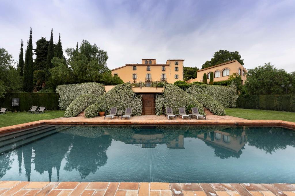 圣维森特-德蒙塔尔特达尔特莫拉酒店的一个带椅子的游泳池和一个背景房子
