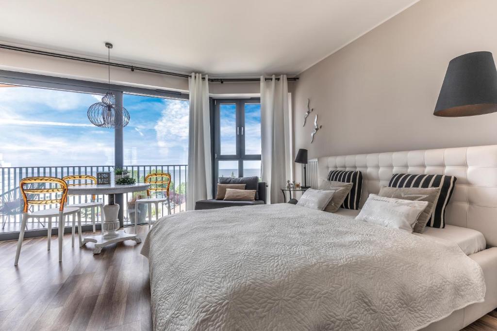 米兹多洛杰Apartament Prestige & Sea Horyzont 613的卧室配有一张床和一张桌子及椅子