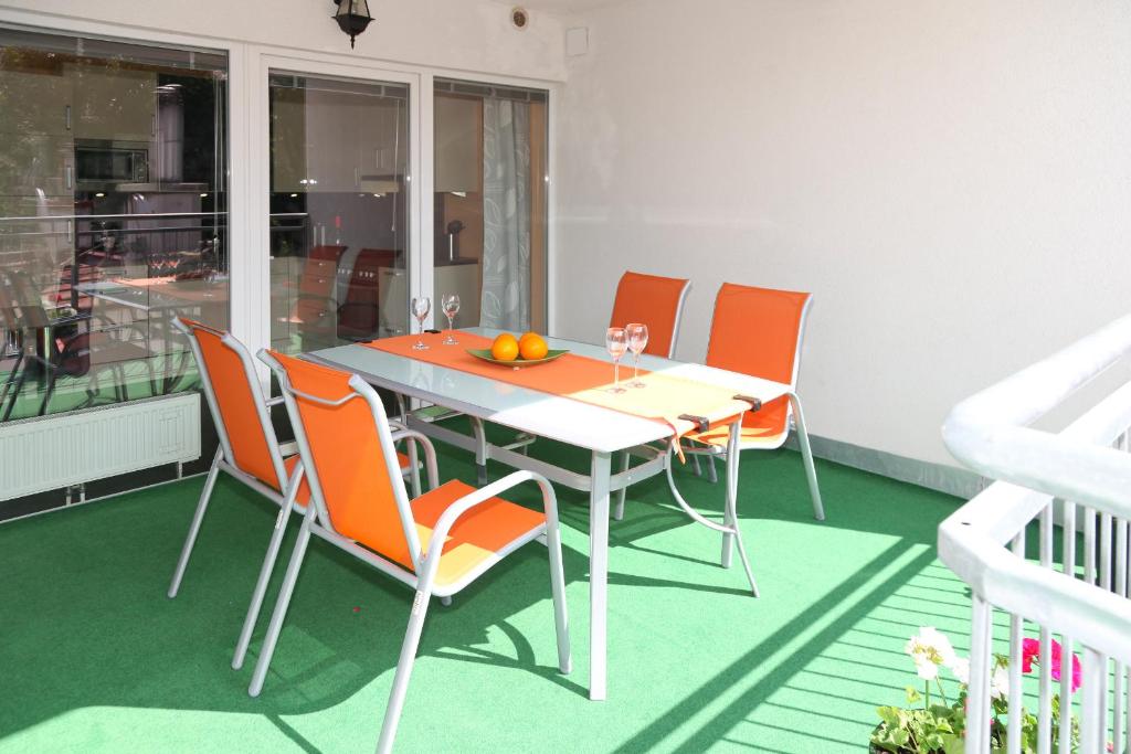 维也纳3 rooms Sunny Apartments-Schoenbrunn, 100m2 with balcony的阳台上配有带橙色椅子的餐桌