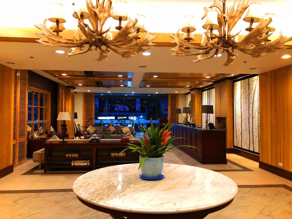 碧瑶斯特旅途中心赛达峰公寓的大堂设有一张桌子,上面有花瓶