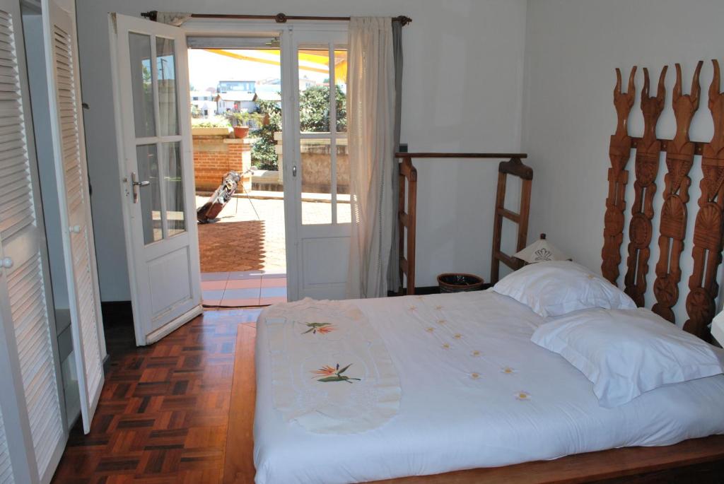 安齐拉贝马斯罗伊公寓式酒店的一间卧室设有一张床,并有通往庭院的门