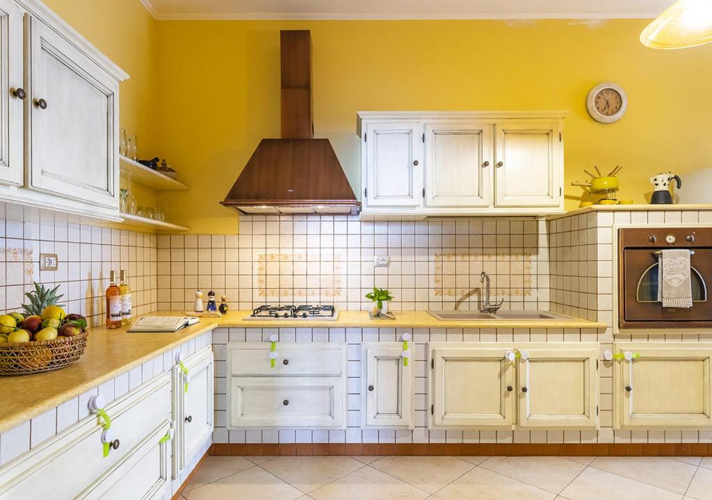 玛丽娜迪曼卡维萨Dimora Smeraldo的厨房设有黄色的墙壁和白色的橱柜