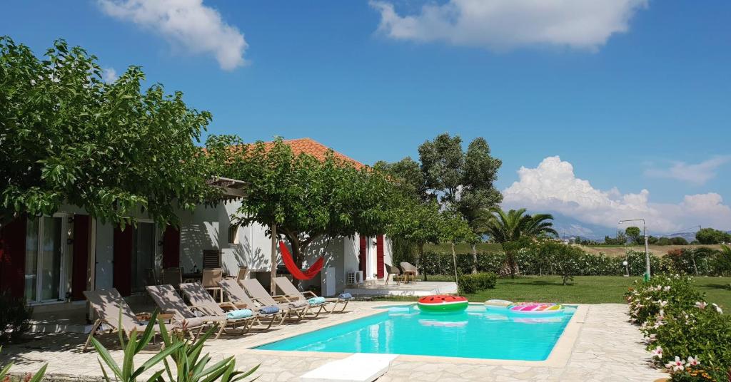 里科索翁Kefalonia Private Paradise的一个带椅子的游泳池以及一座房子