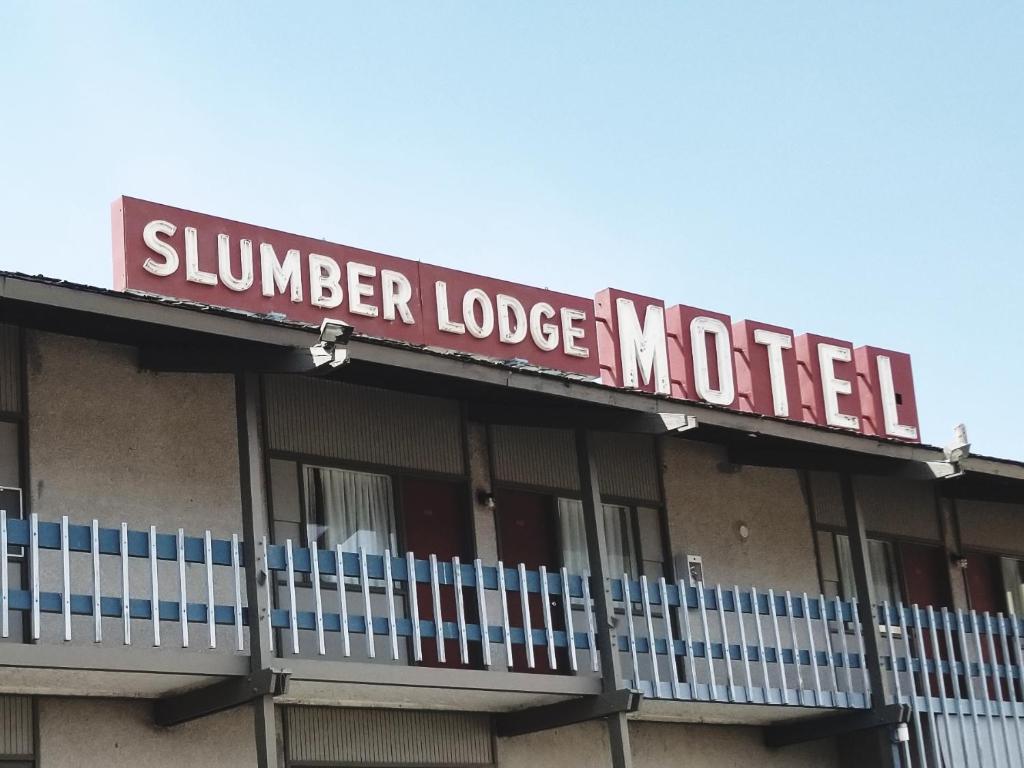 威廉斯莱克Slumber Lodge Williams Lake的一座带标志的建筑,上面写着夏季旅馆