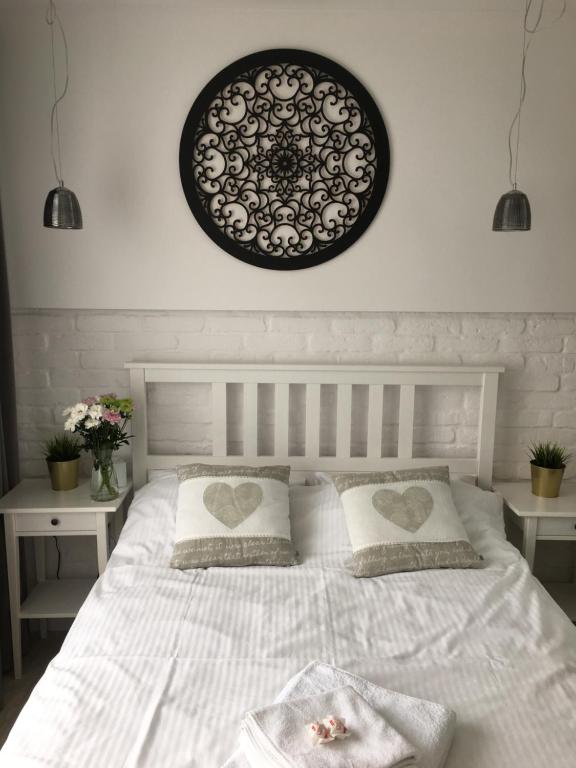 奥尔什丁kameralny apartament的卧室配有一张白色床,墙上有两颗心