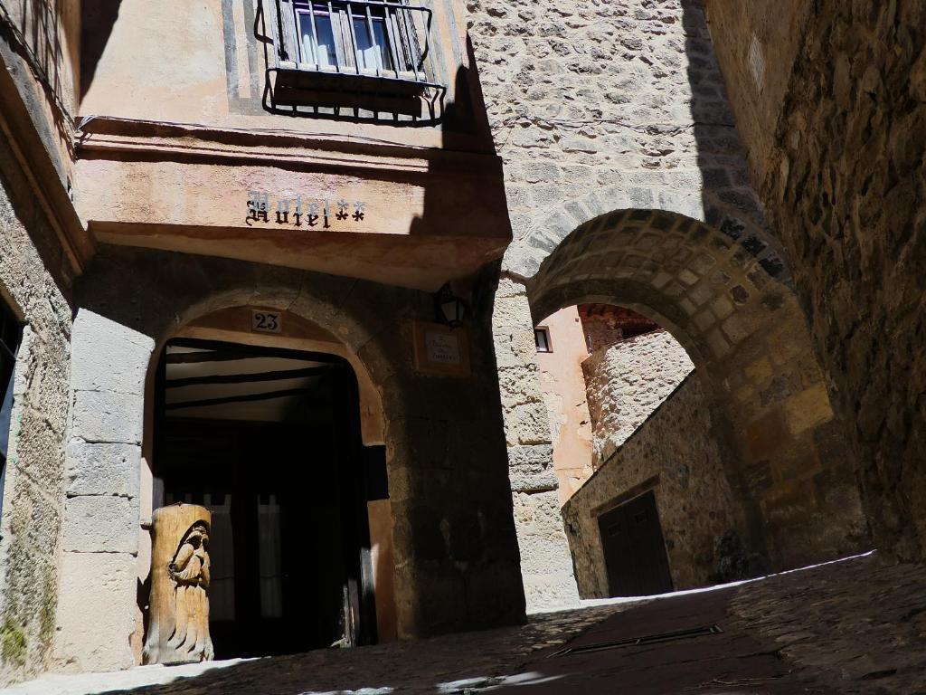 阿尔巴拉辛Hotel Posada del Adarve的门廊上有一狮子雕像的建筑物