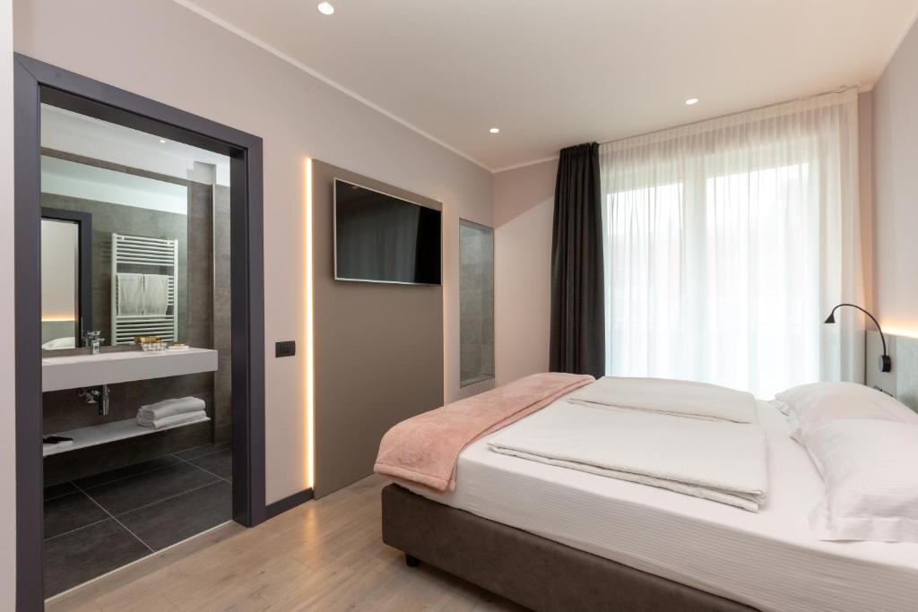 加尔达湖滨Garda Life的一间卧室配有床、水槽和镜子