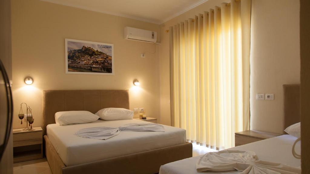 都拉斯Villa Balani的酒店客房设有两张床和窗户。