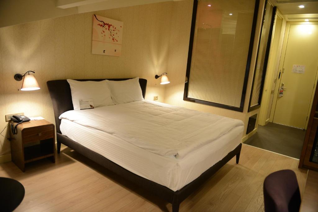 阿达纳阿达纳假日酒店 的一间卧室配有一张带白色床单的床和一扇窗户。