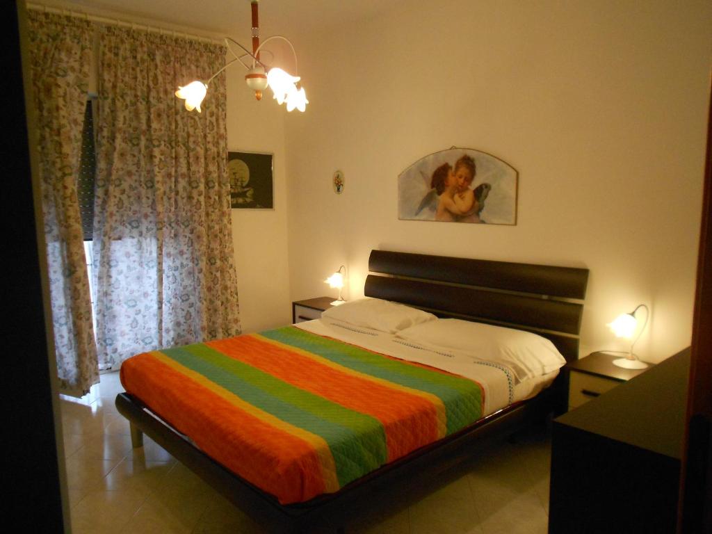 加埃塔Casa Magnolia的一间卧室配有一张带彩色条纹毯子的床