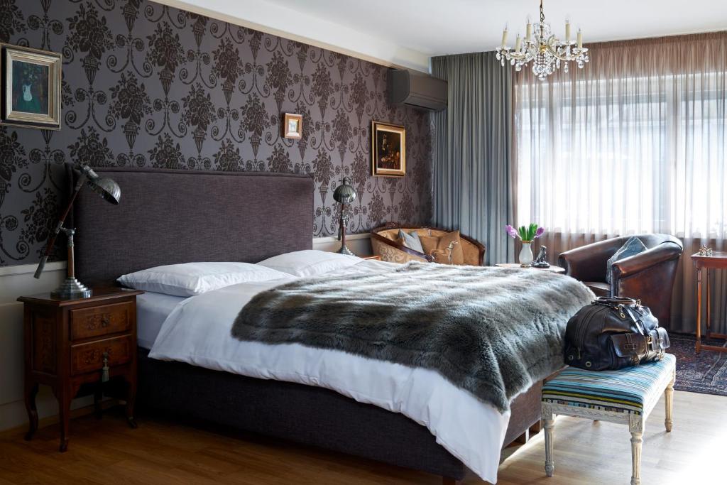 苏黎世市政厅精品酒店的一间卧室配有一张大床和一个吊灯。