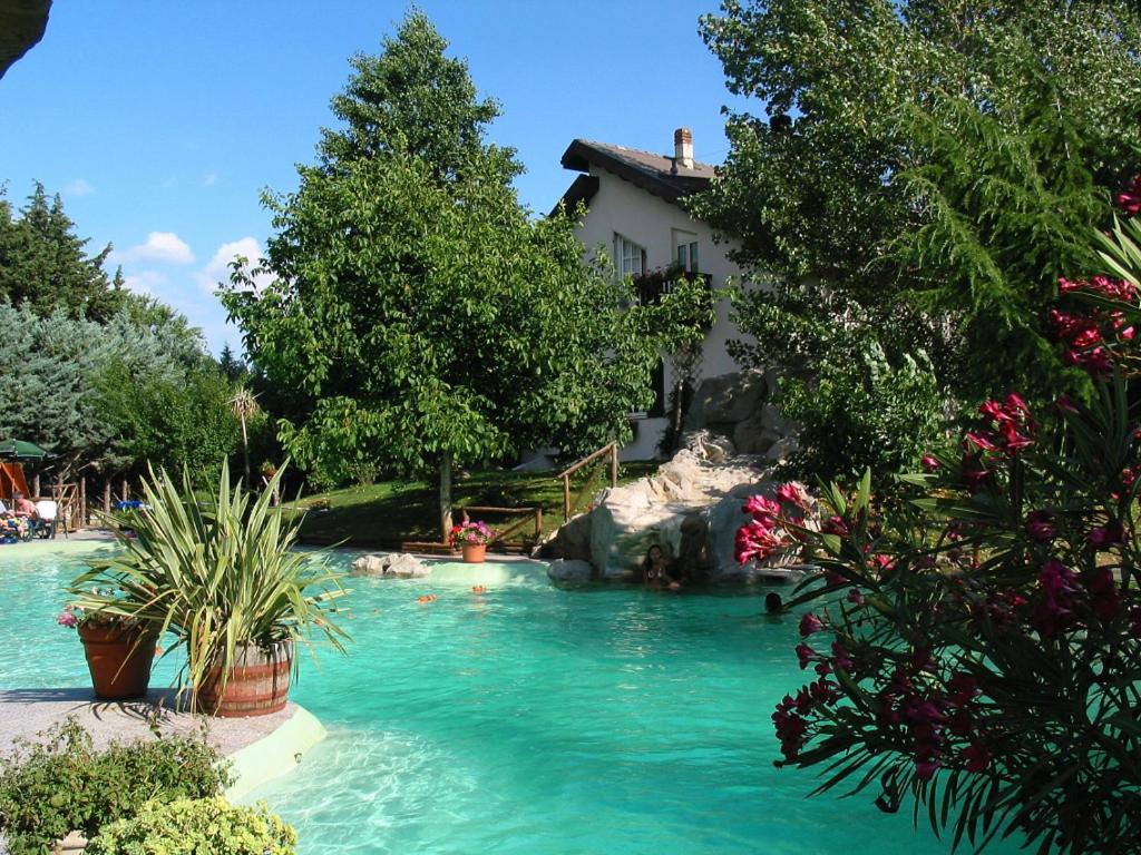 莫拉诺卡拉布罗Agriturismo La Locanda Del Parco的一座房子前面的蓝色海水游泳池