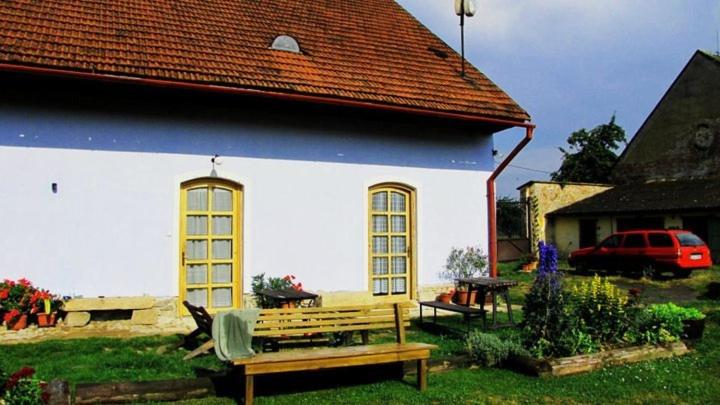 Borovná波罗乌内迪乌德酒店的一座蓝色和白色的房子,在院子里设有长凳