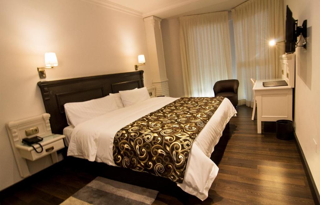 维拉新安怡维拉奥泰尔酒店的酒店客房设有一张大床和一张书桌。