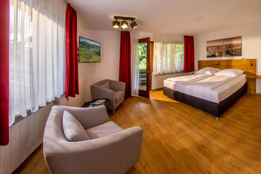 奥伊-米特尔贝格Appartement-Hotel-Allgayer的一间卧室配有一张床、一张沙发和椅子
