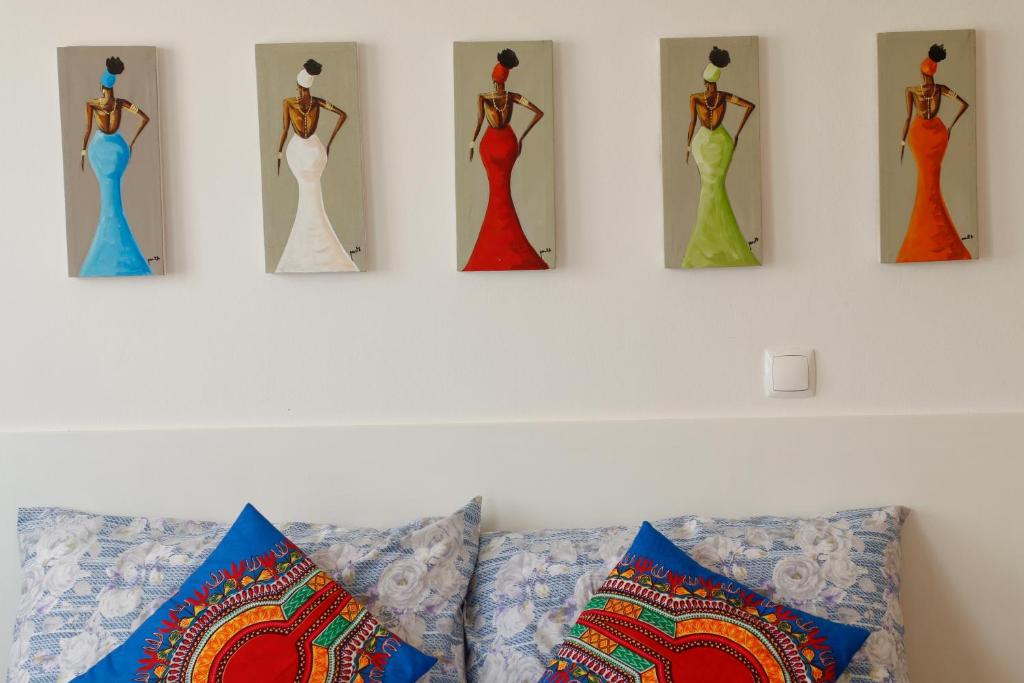 萨尔雷Boteto Tamtama Apartments的墙上挂着四件连衣裙的墙