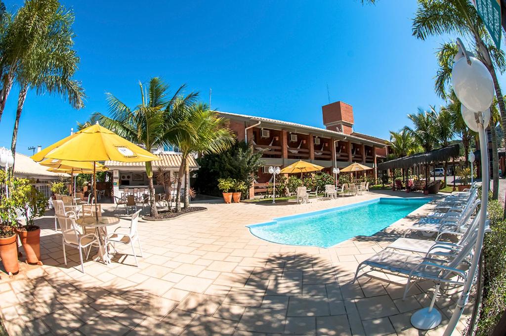 巴拉奈里奥-坎布里乌蓬塔多罗布酒店的一个带椅子和遮阳伞的游泳池的度假酒店