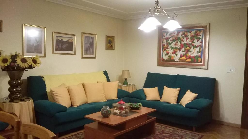 庞特维德拉Habitacion Privada en Piso Familiar的客厅配有蓝色的沙发和桌子