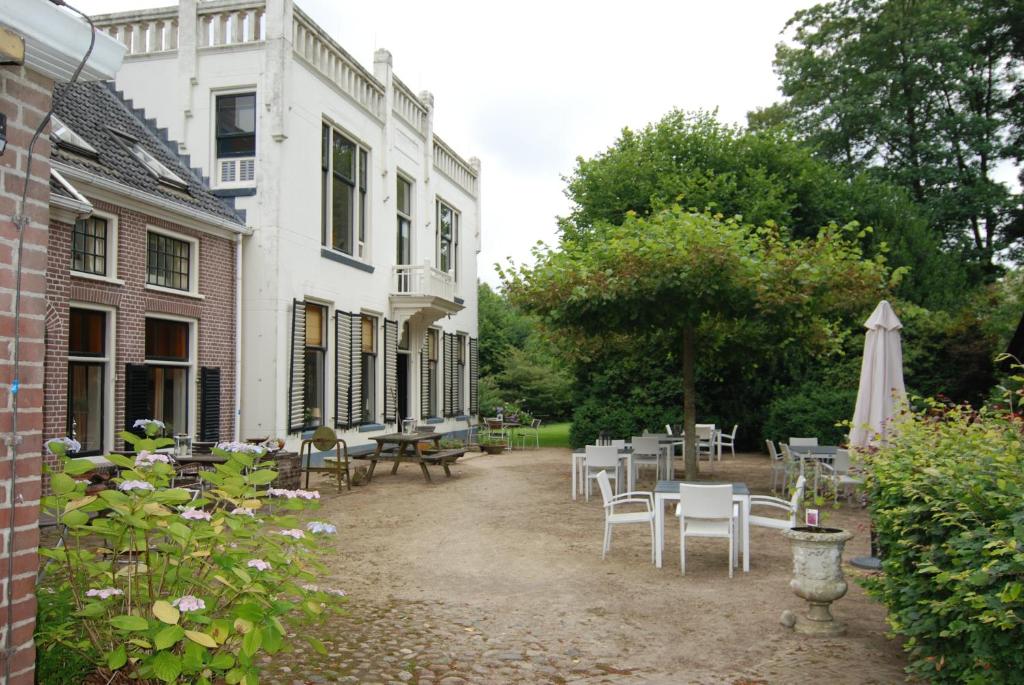 WesterveldeDe Jufferen Lunsingh的一个带桌椅的庭院和一座建筑