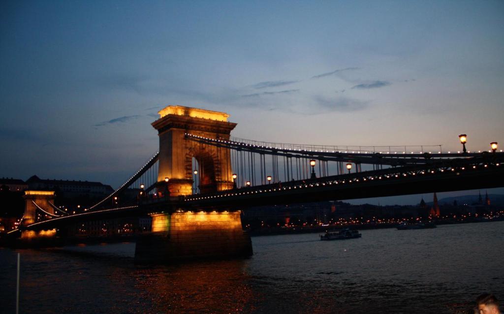 布达佩斯Elite Rooms & Apartments的夜间在水面上筑起一座灯桥