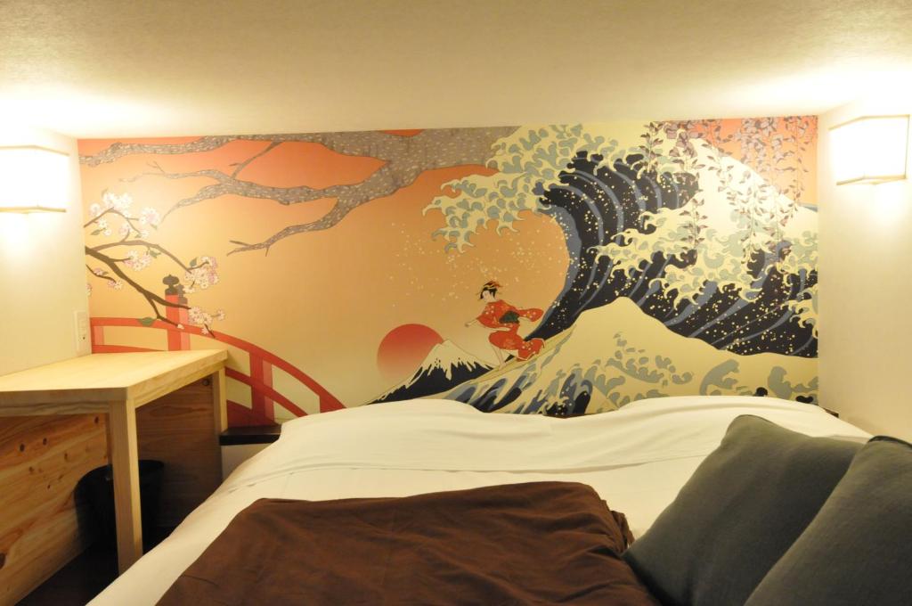 富士市纳思比富士山背包客旅馆的卧室墙上有波浪画