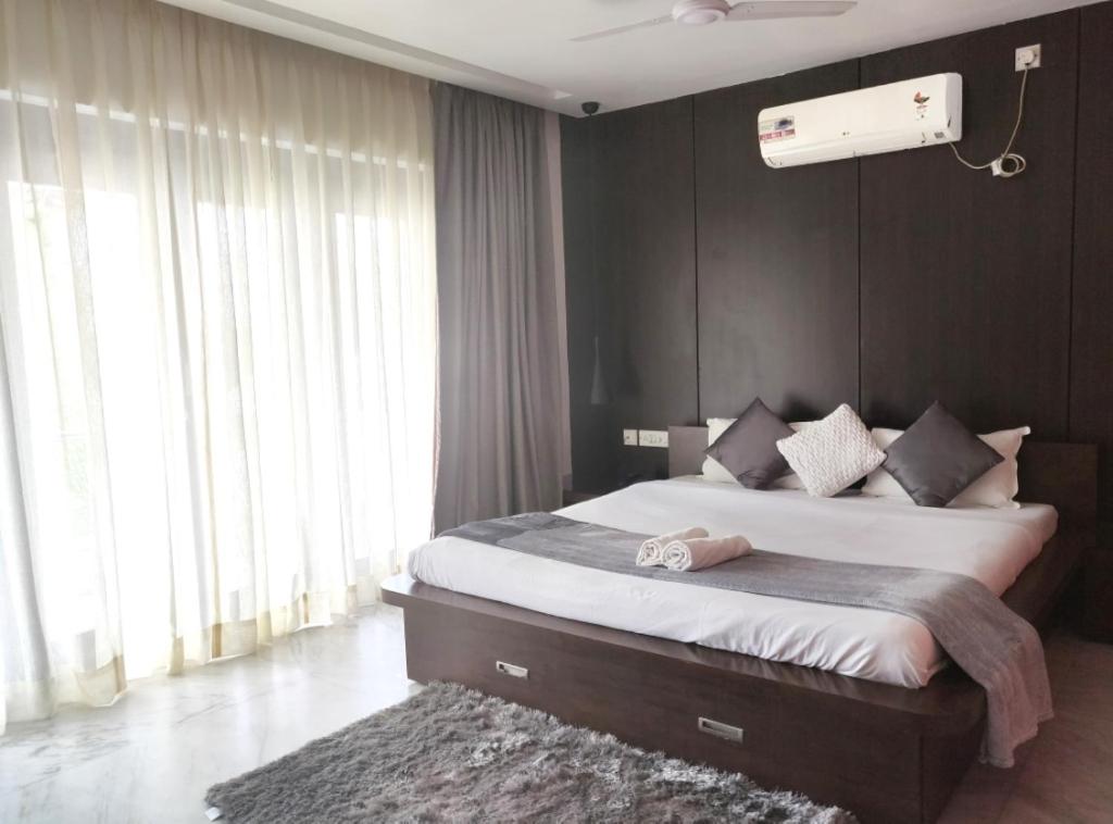加尔各答塔特宛住宿酒店的一间卧室设有一张大床和一个大窗户
