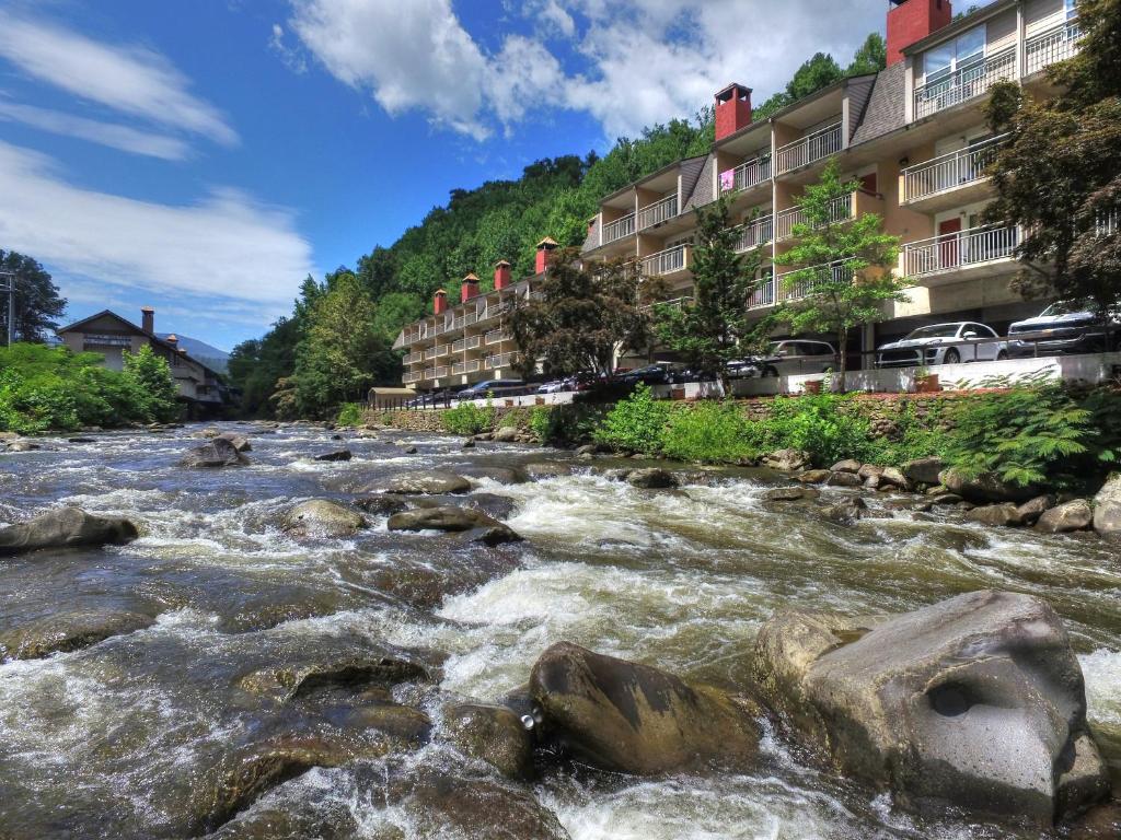 加特林堡Gatlinburg River Inn的建筑物前有急流的河流