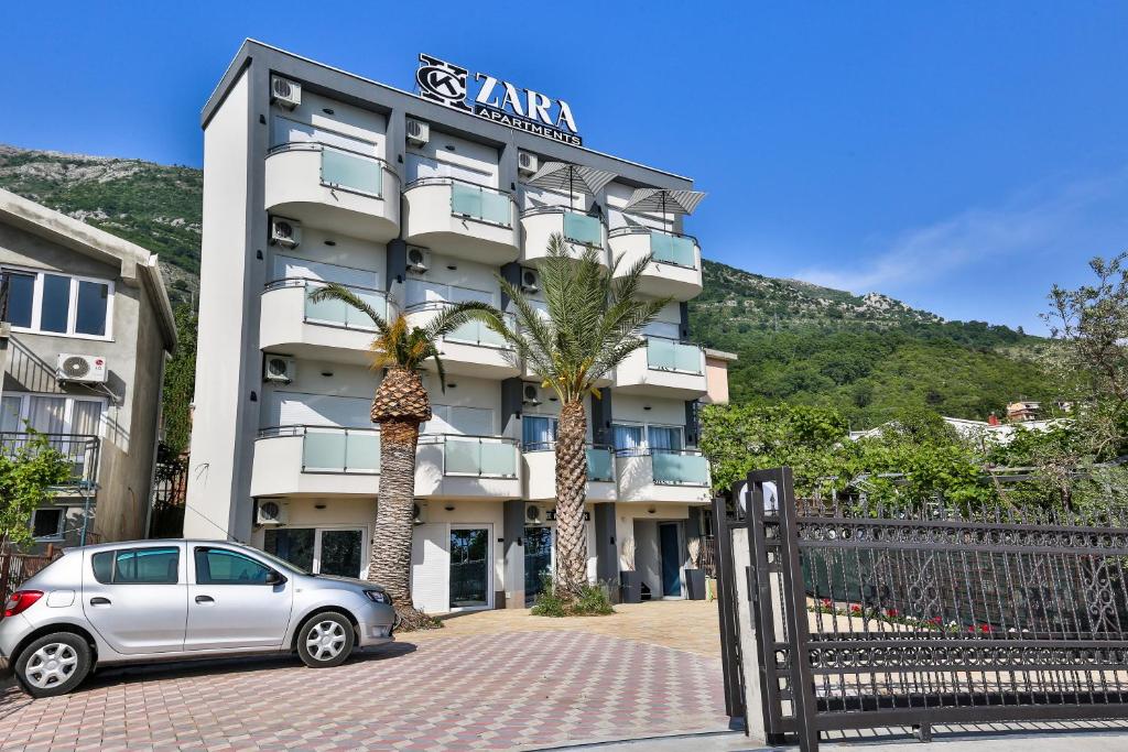 苏托莫雷Zara apartmani Sutomore的停在酒店前的停车场